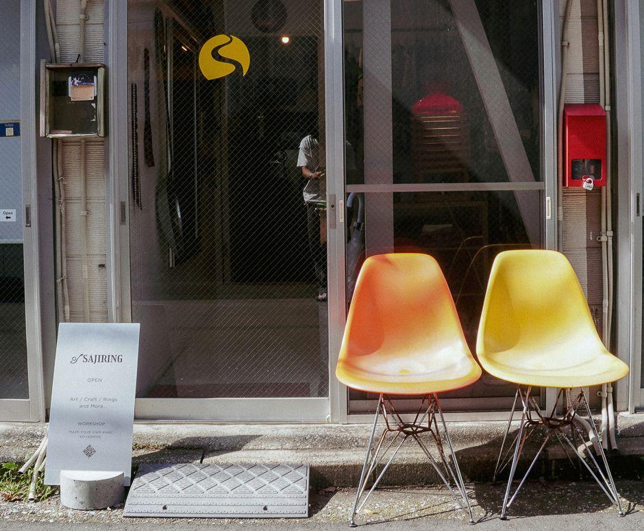 黄色とオレンジの椅子が並ぶ店の入口